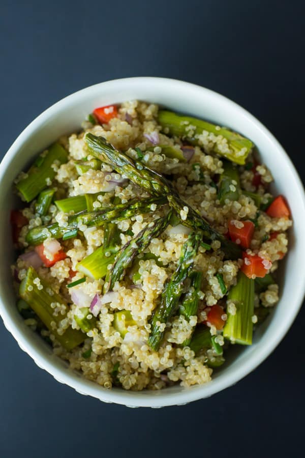 A bowl of quinoa salad with roasted asparagus.