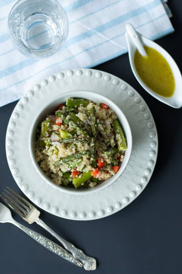 quinoa salad with roasted asparagus in with bowl with dressing on the side