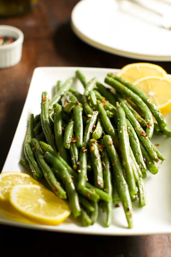 Crispy baked green beans in a white serving platter.