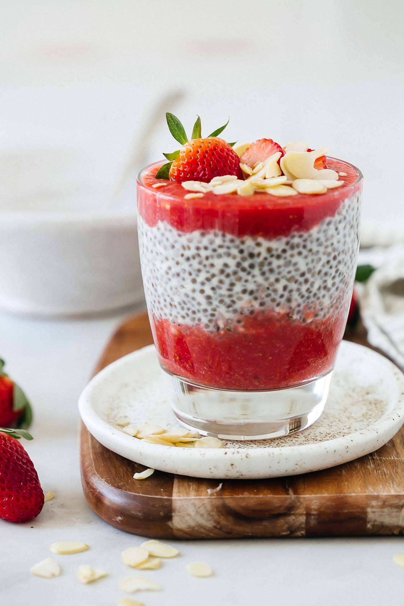 Strawberry chia seed pudding with strawberries and almonds on top.