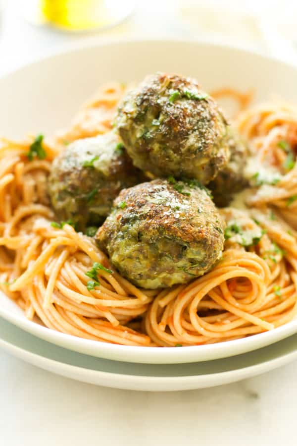 Close up of Kale Sneak in Turkey Meatballs on top of pasta.