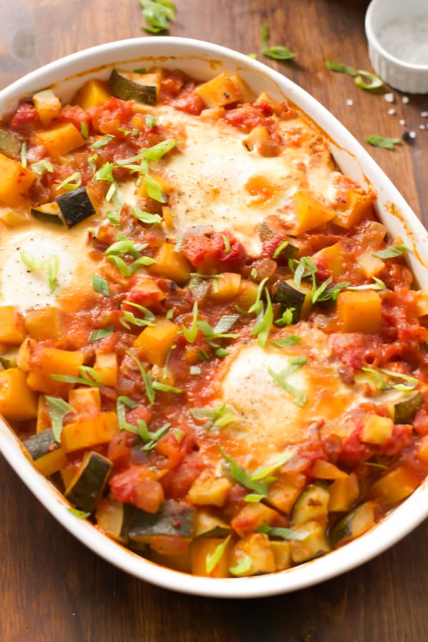 Close up image of a baking dish with baked eggs with veggies.
