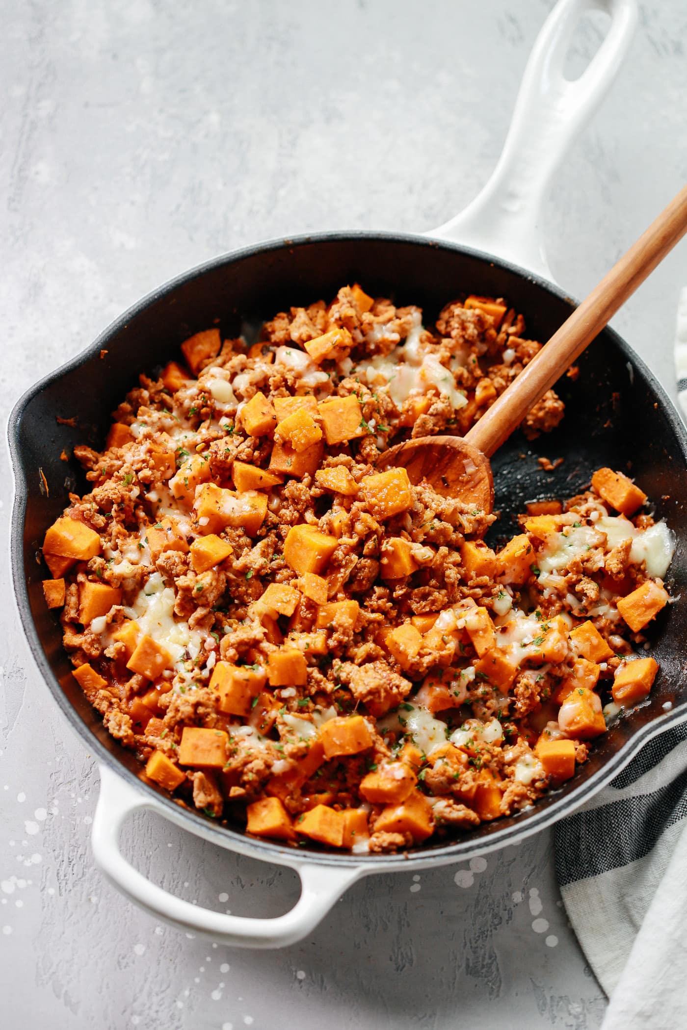 overhead view of a white skillet containing ground turkey and sweet potato