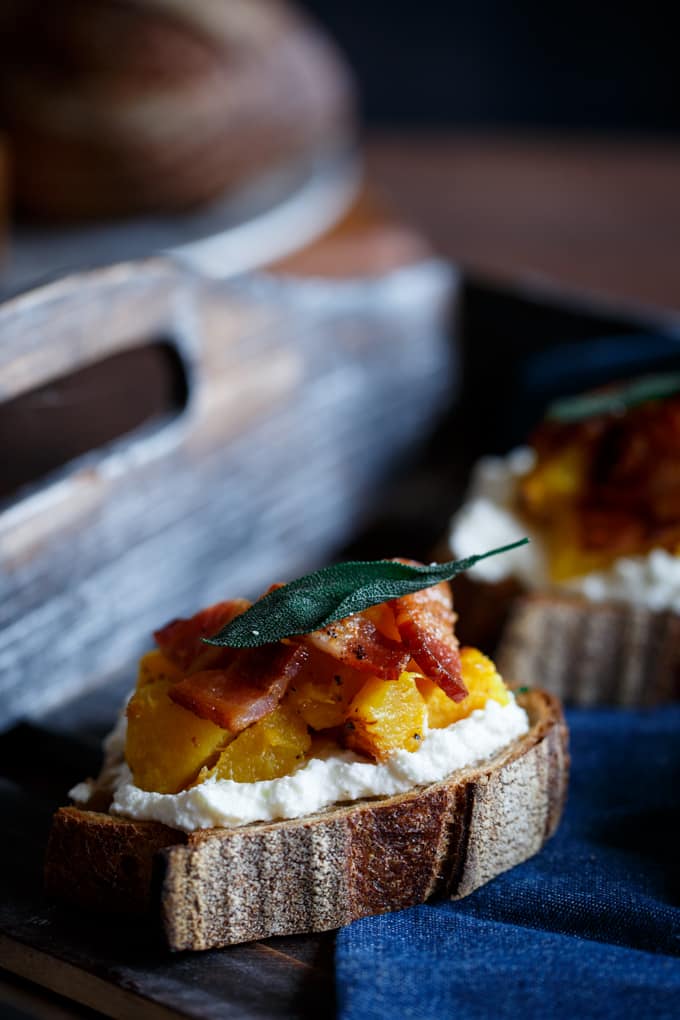 Close up of an acorn squash honey bacon crostini.