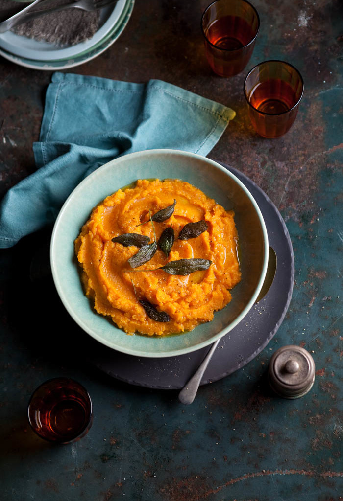 A bowl of butternut and sweet potato mash with crispy sage leaves.