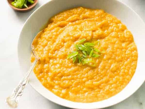 A bowl of creamy carrot leek soup.