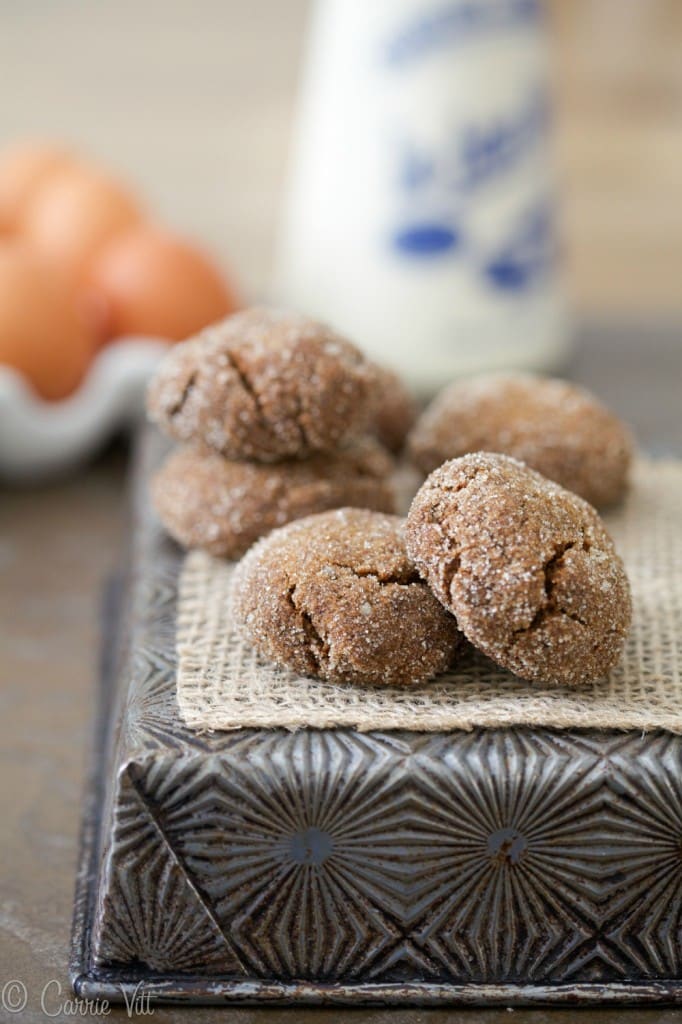 Molasses cookies coated in sugar on top of a decorative baking pan.