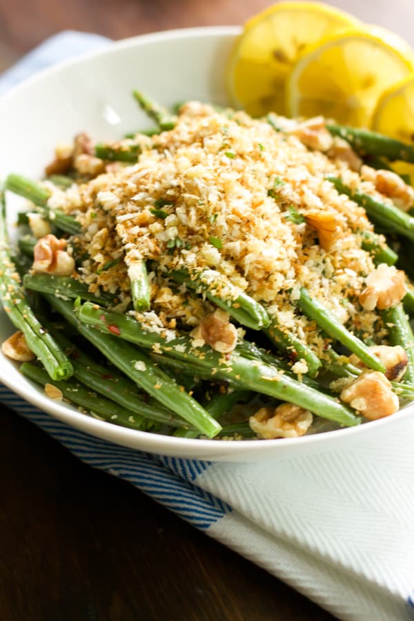 Close up image of a bowl of roasted green beans with garlic panko.