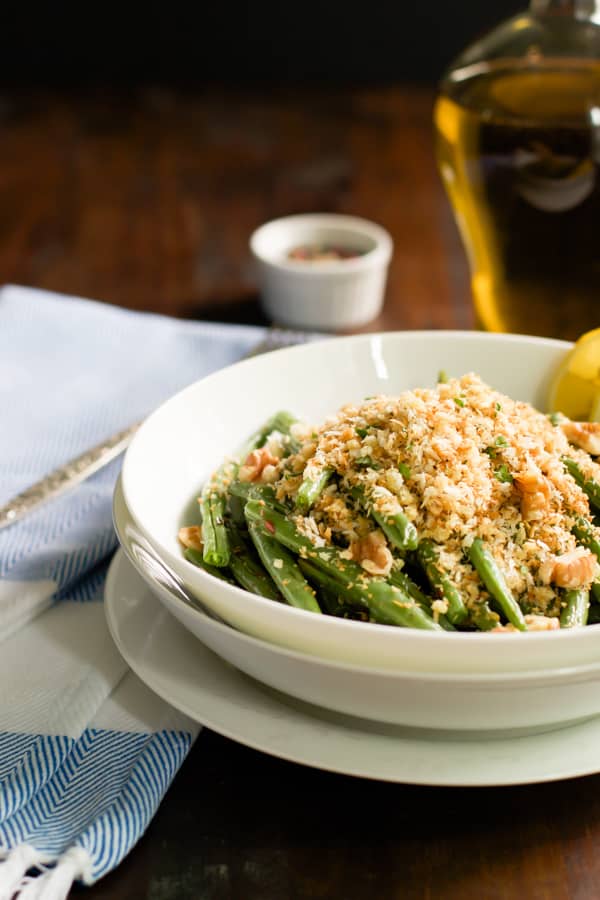 A side photo of a bowl of roasted green beans with garlic panko.