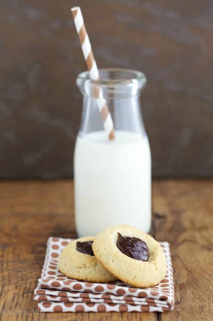 Thumbprint cookies with a glass of milk in the background.