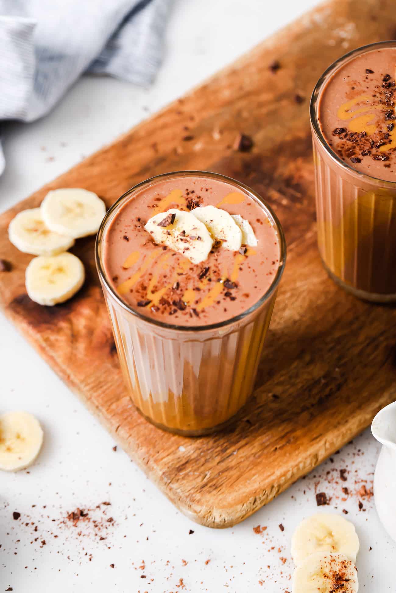 A peanut butter chocolate smoothie garnished with banana slices.