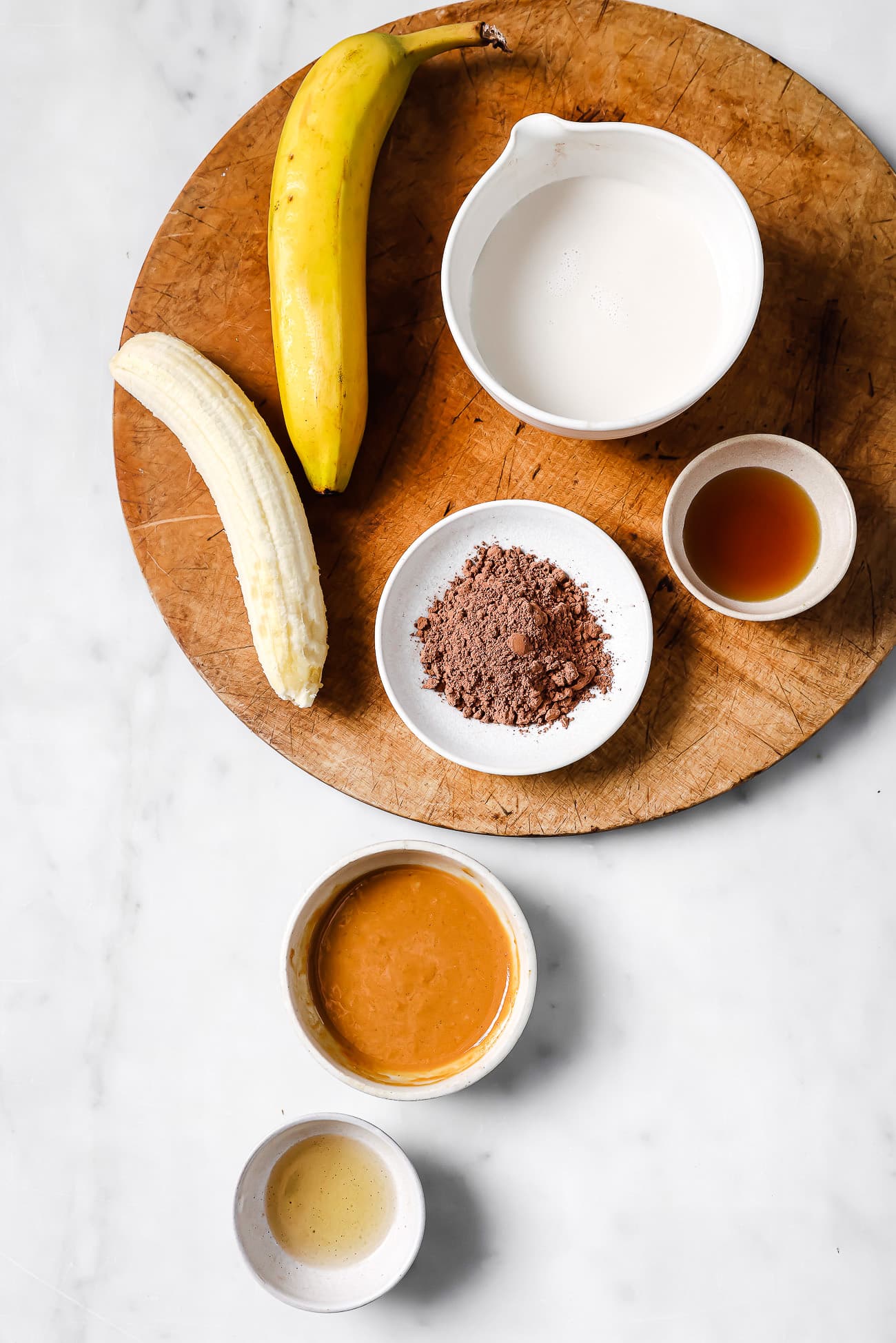 Pre-measured ingredients on a wooden cutting board and white countertop.