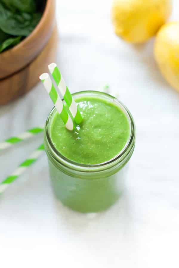 overhead view of a green smoothie in a mason jar with a straw 