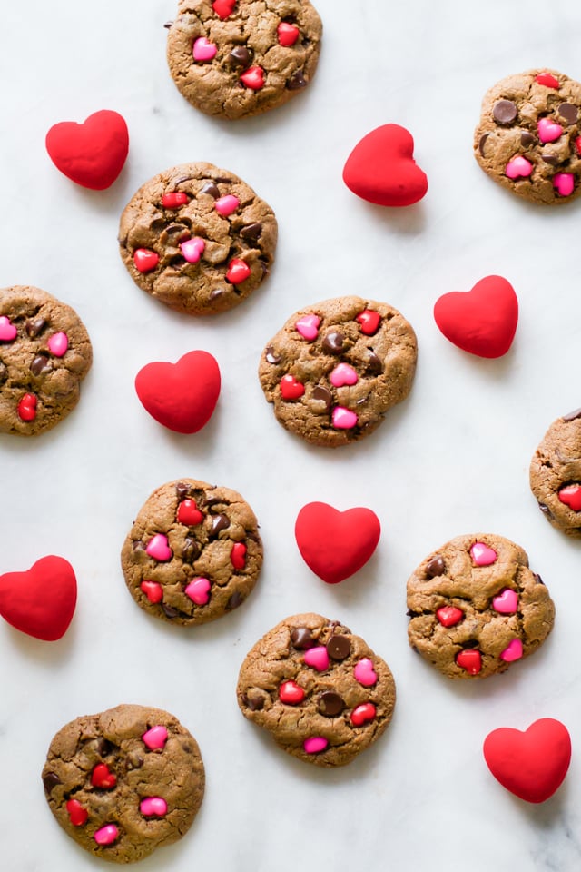 Overhead image of ten valentine's cookies with hearts around it.