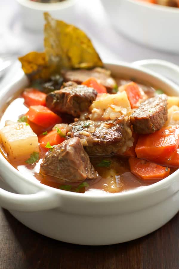 Close up of a bowl of stew with beef and vegetables.