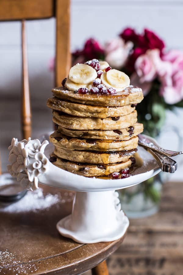 A stack of ricotta chocolate chip banana and chia pancakes on a cake stand.