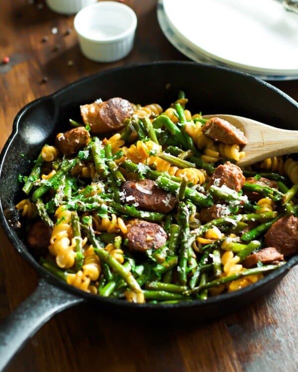 Sausage asparagus quinoa pasta in a cast iron skillet.