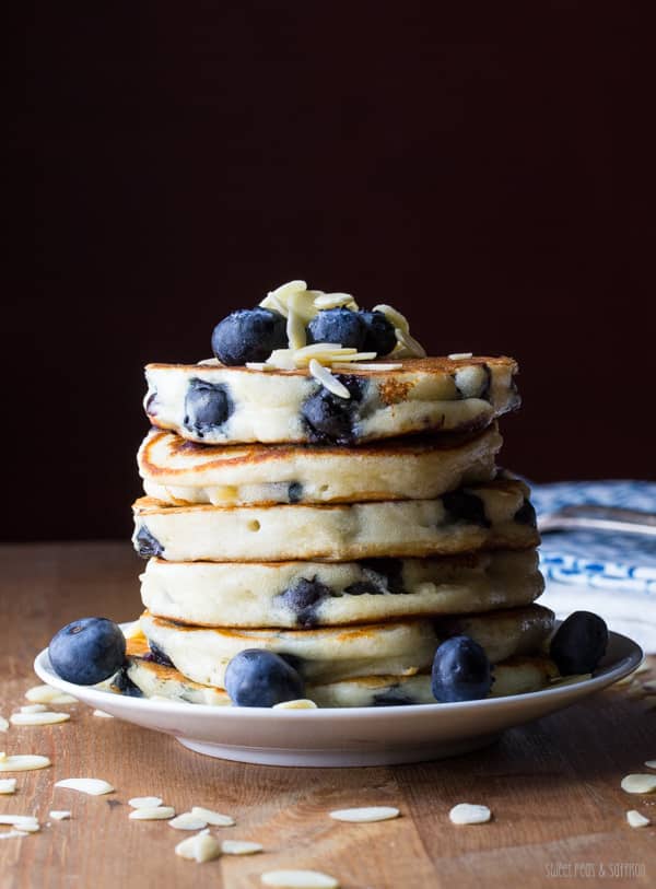 blueberry almond pancakes A stack of blueberry almond pancakes with whole blueberries and sliced almonds on top.