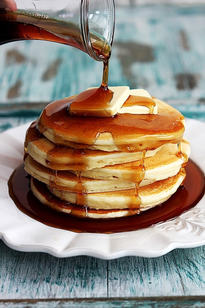 greek-yogurt-pancakes-7 A plate of Greek yogurt pancakes with two pats of butter and syrup poured on top.