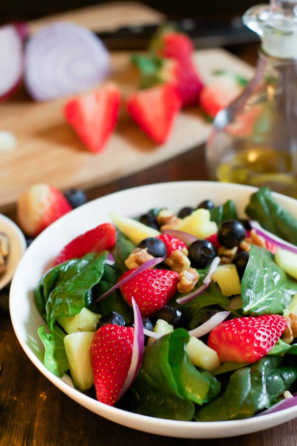 A bowl of spinach fruit salad.