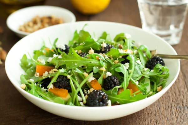 A close up of arugula blackberry salad.