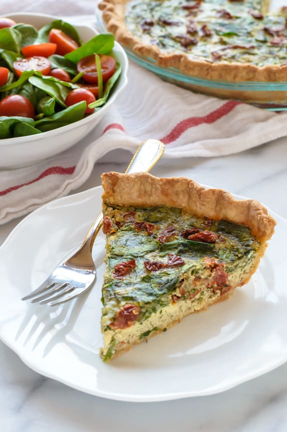 Pesto-Quiche-with-Sundried-Tomatoes-and-Parmesan.-Beautiful-and-healthy-too A slice of pesto quiche with sun-dried tomatoes and parmesan.