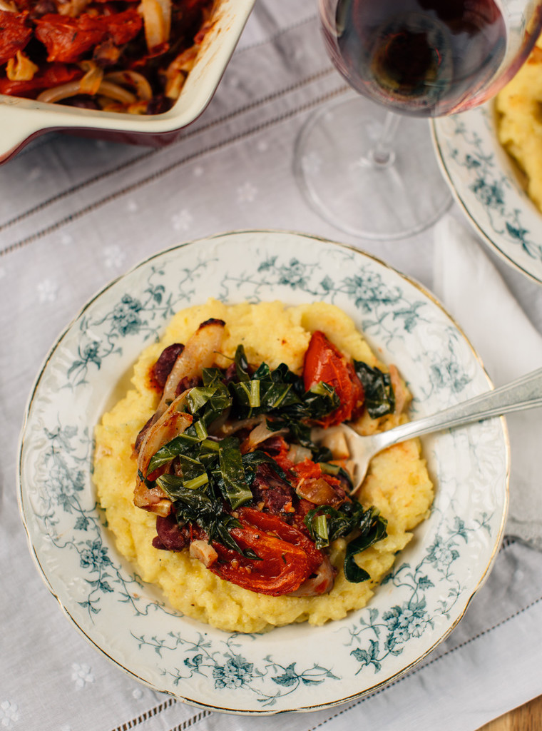 Polenta with slow roasted tomatoes & collard greens in a plate.