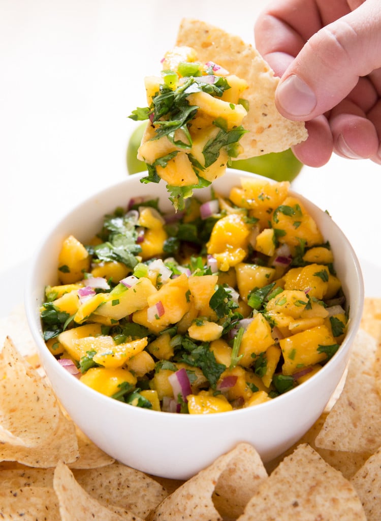 Tropical-Mango-Papaya-Fruit-Salsa-1 Tropical mango papaya fruit salsa in a bowl with a tortilla chip scooping some out.