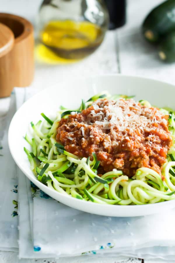 A white bowl containing turkey bolognese with zucchini pasta.