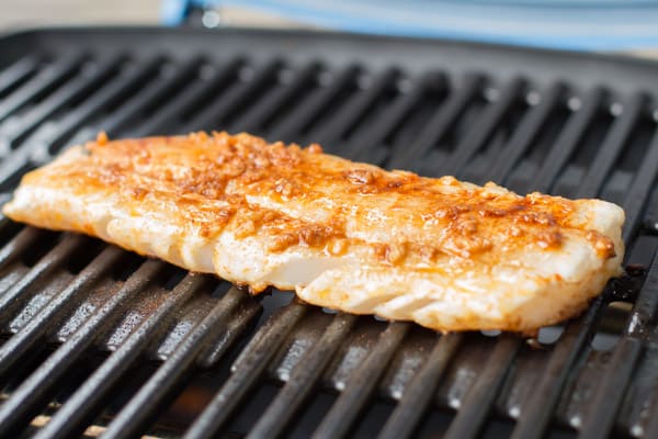 A piece of fish on a grill.