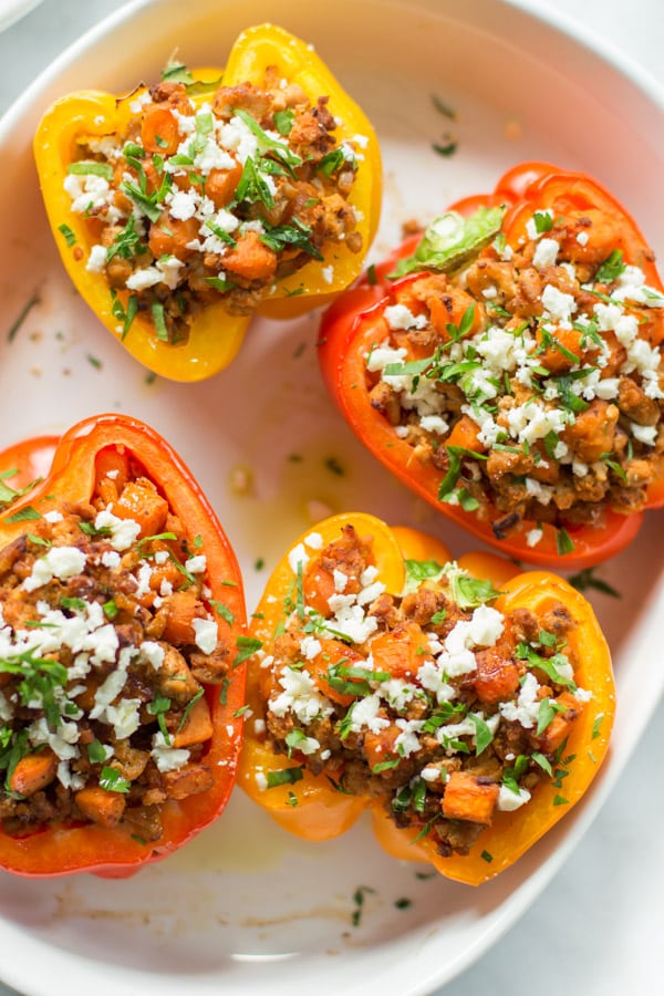 Four ground turkey sweet potato stuffed peppers inside of a large serving bowl.