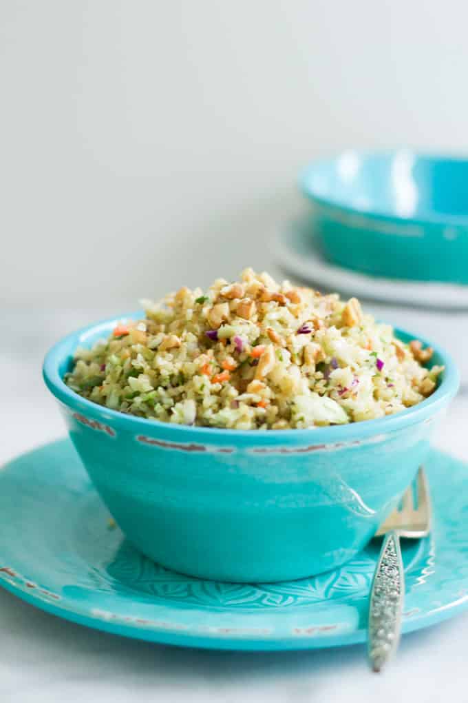 A teal bowl of quinoa cabbage salad.