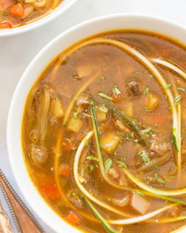 Close up of a bowl of zucchini noodle soup.