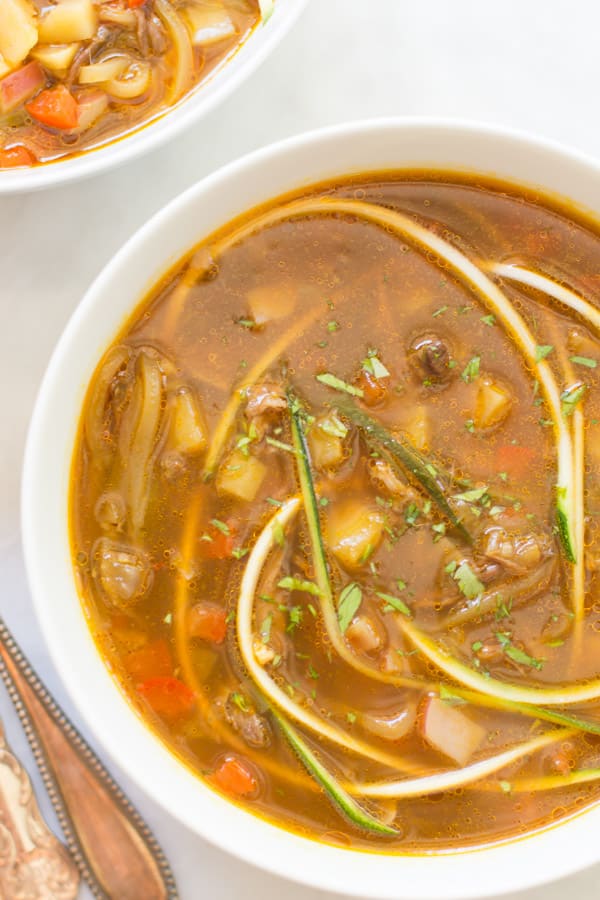 Close up of a bowl of zucchini noodle soup.