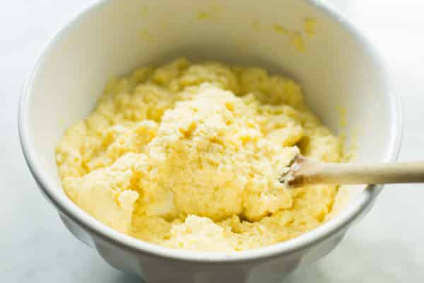 Ricotta cheese mixture in a bowl with a spoon. 