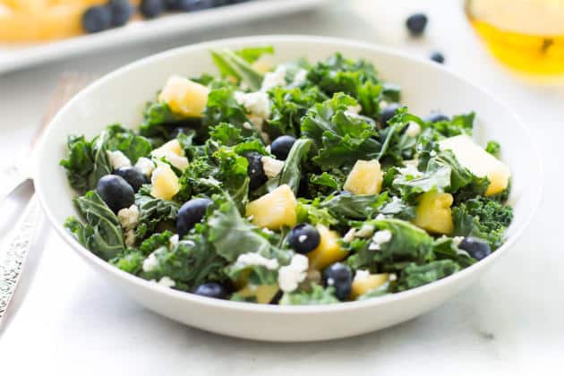 Bowl of kale blueberry pineapple salad.