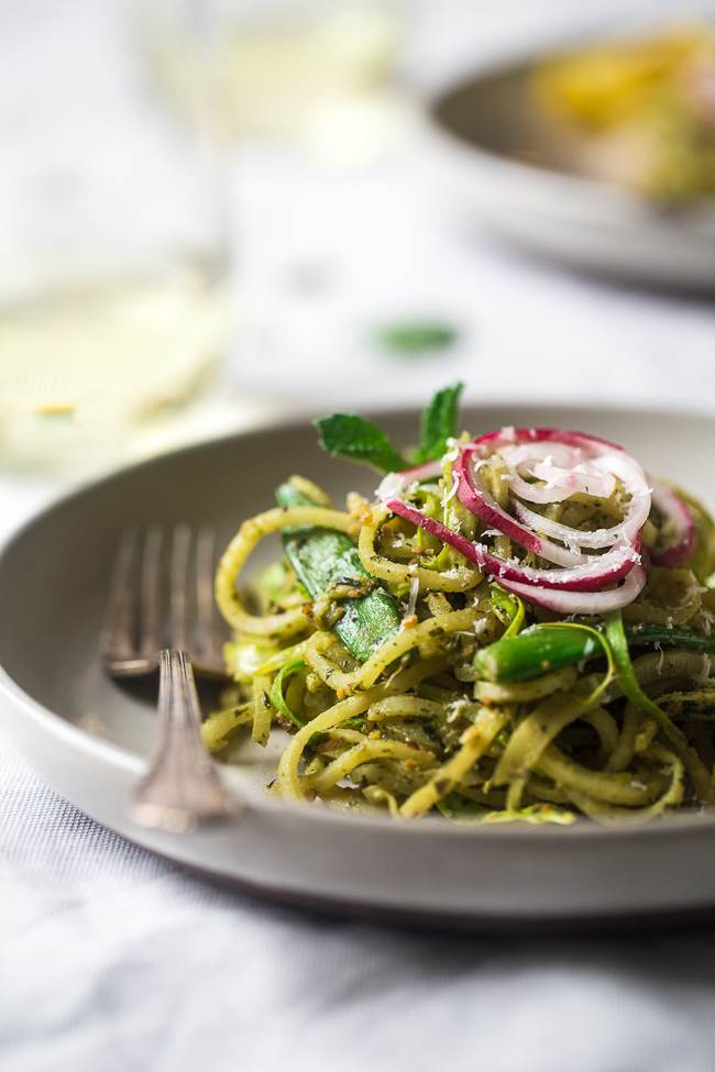 Spiralized turnip noodles and vegetables in a gray bowl with a fork in it.