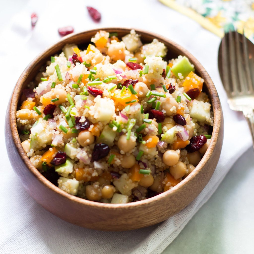 A bowl of cranberry apple quinoa salad with chives on top.