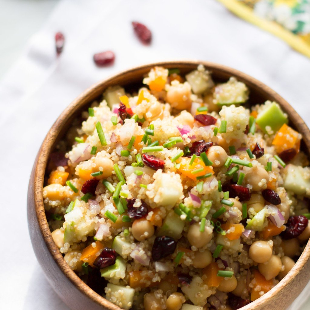 Close up of a wooden bowl of cranberry apple quinoa salad.