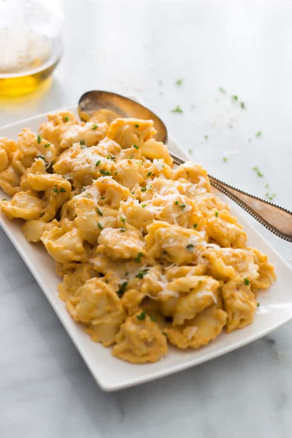A plate of tortellini with pumpkin sauce.