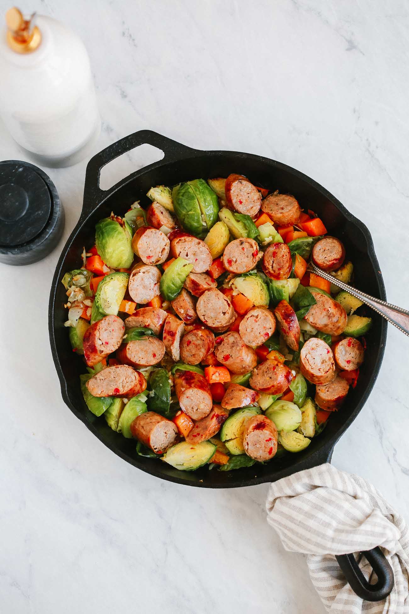 Head shot of a skillet of Brussels sprouts and sausage.