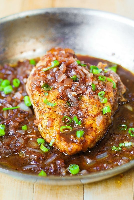 A skillet containing Pan-Seared Chicken Breast garnished with green onions.