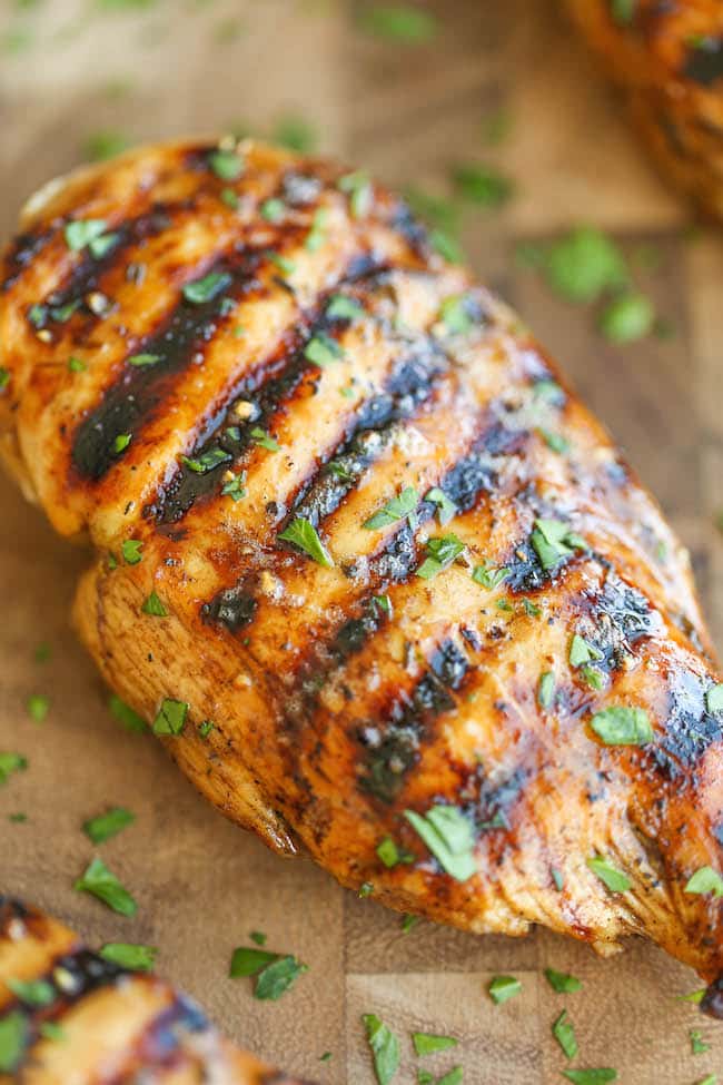 A closeup of Easy Grilled Chicken on a wooden cutting board.