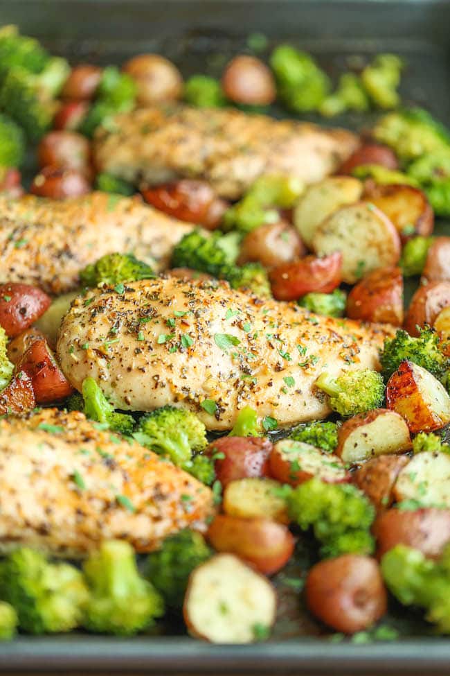 A Close up of Honey Garlic Chicken with broccoli and baby potatoes on a baking sheet.