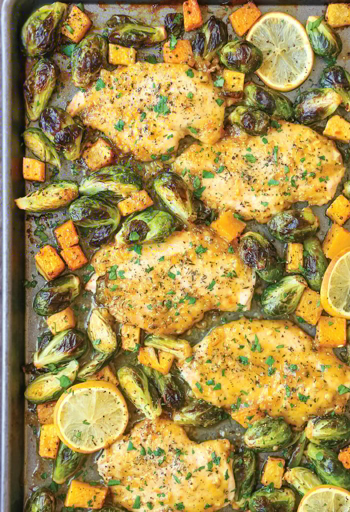 An overhead view of One pan Lemon Chicken With Butternut Squash and Brussels Sprouts on a baking sheet.