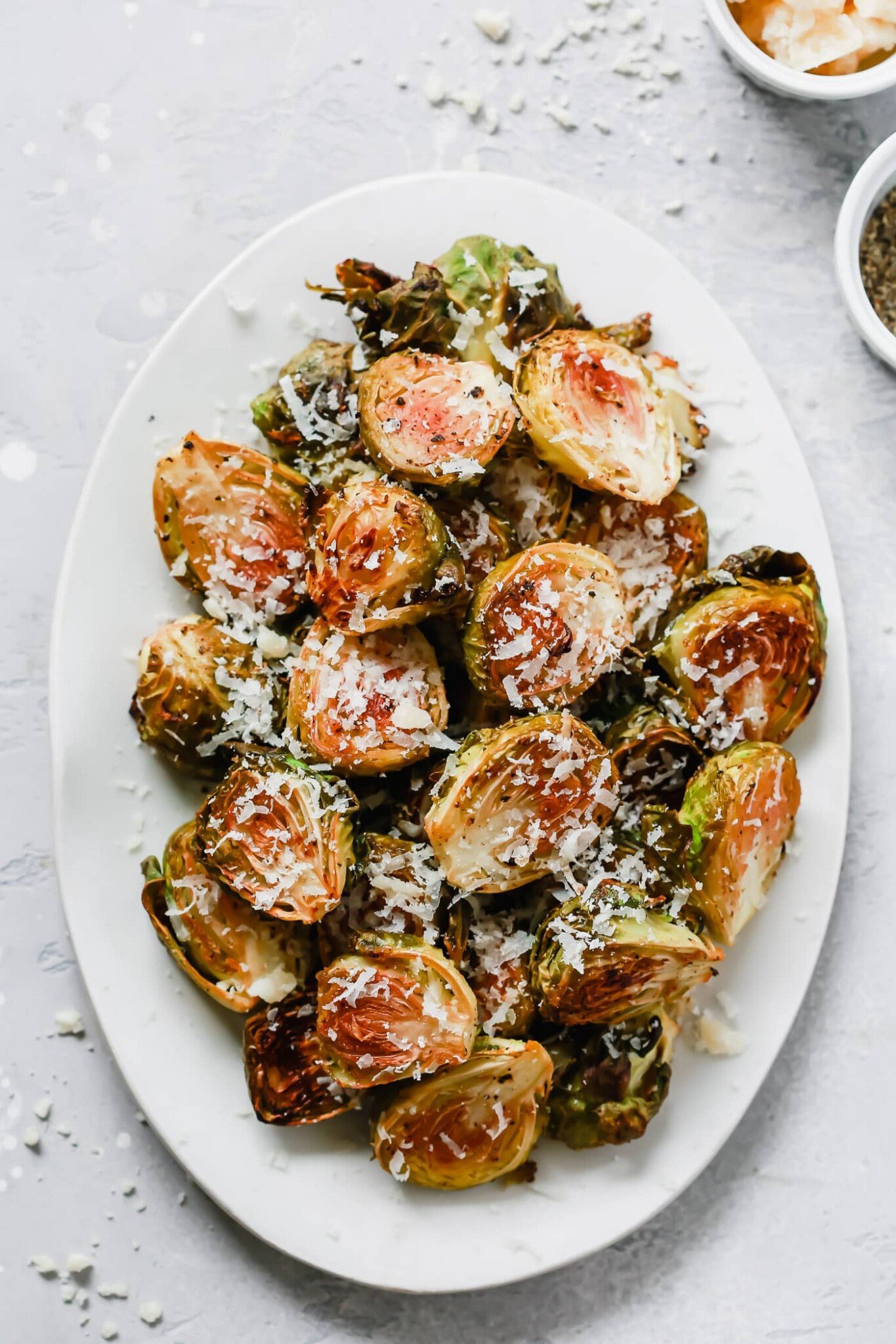 overhead photo of roasted brussel sprouts on a white platter. 