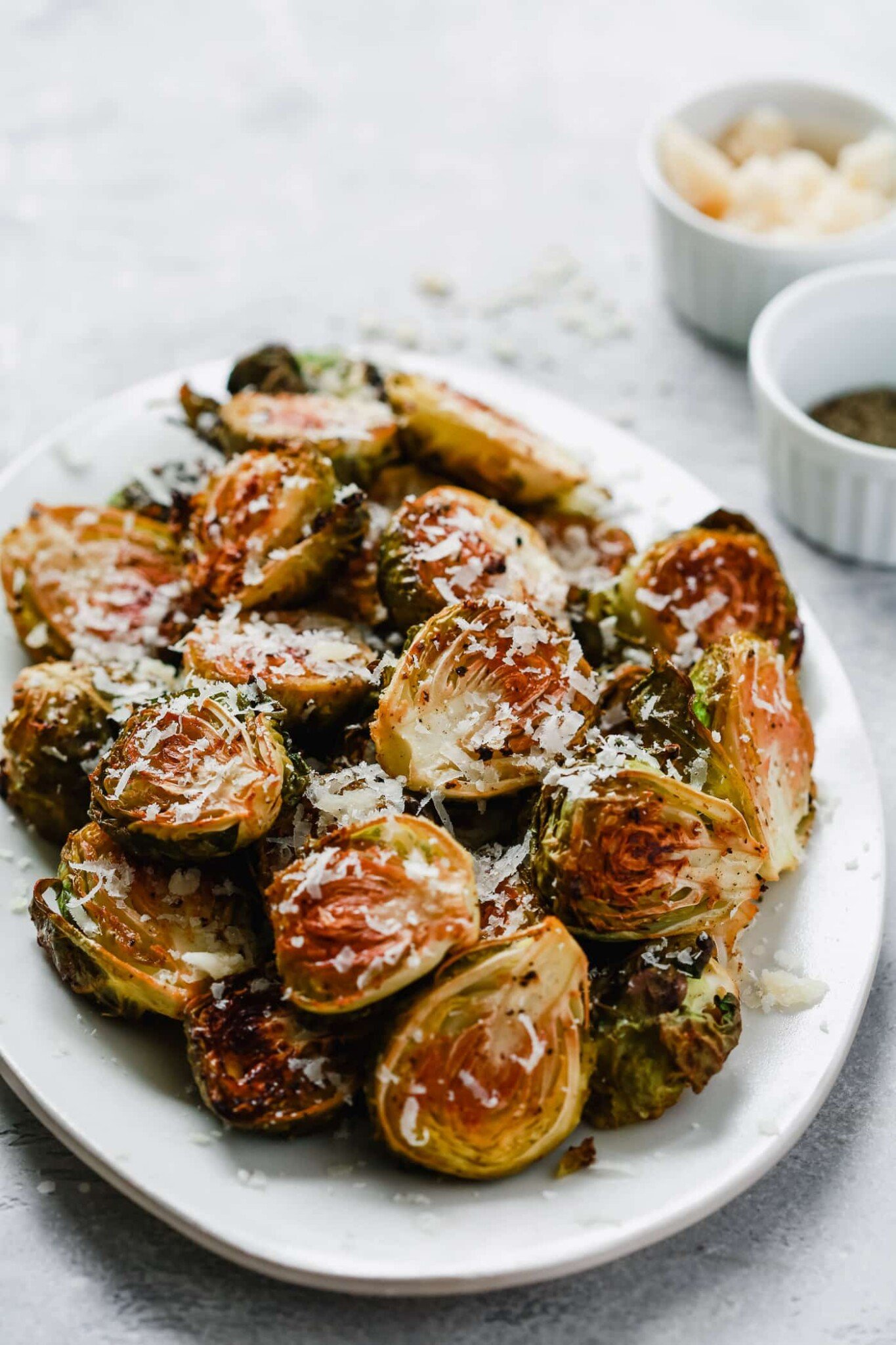 closeup photo roasted Brussel sprouts on a white platter. 