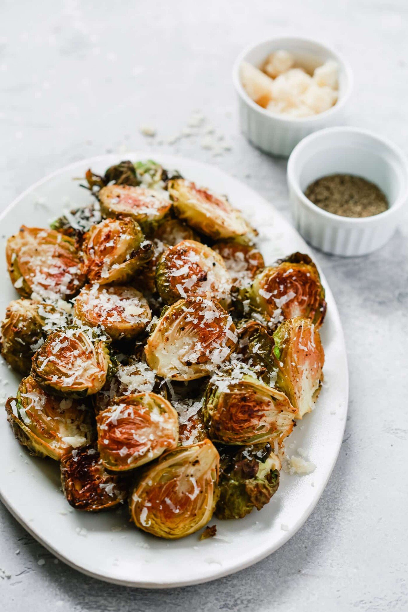 overhead view of roasted Brussel sprouts on a white platter.