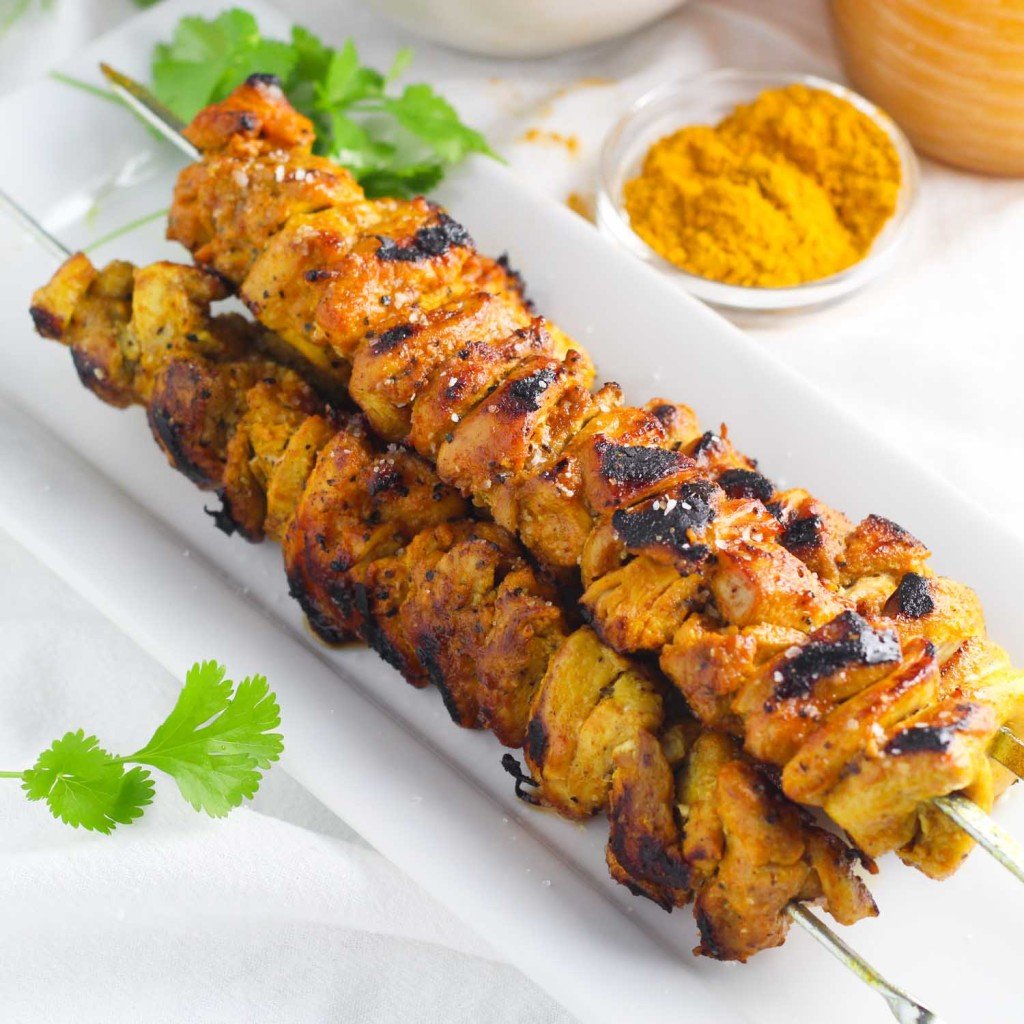 close-up of a Curry Chicken Skewers on a white plate