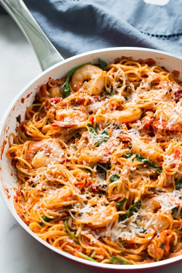 Overhead view of a white pan with spaghetti and shrimp. 